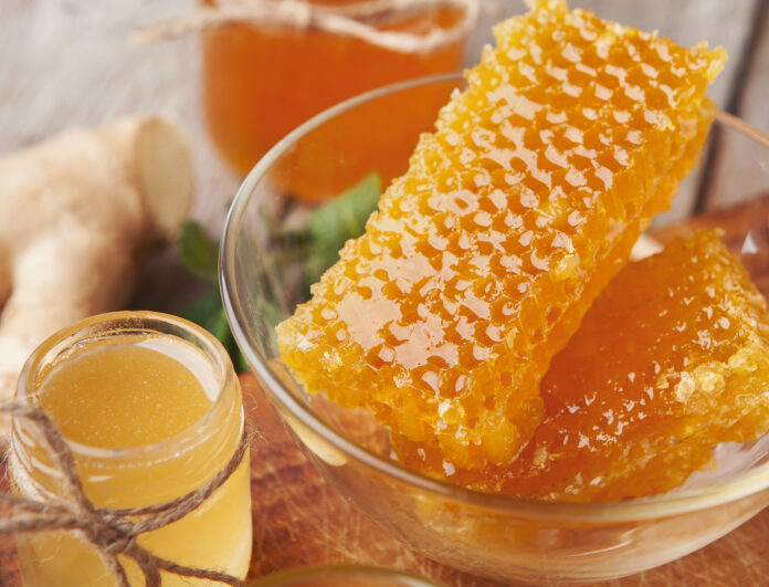 Golden honeycombs and honey jar, closeup